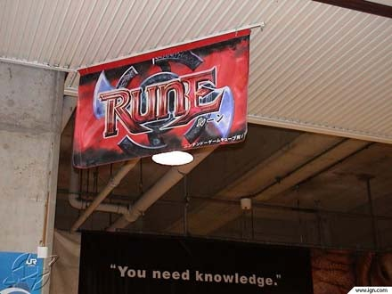 hanging flag banner of the rune logo on a station ceiling, with another banner in the back saying 'you need knowledge.' there are IGN watermarks on the bottom.
